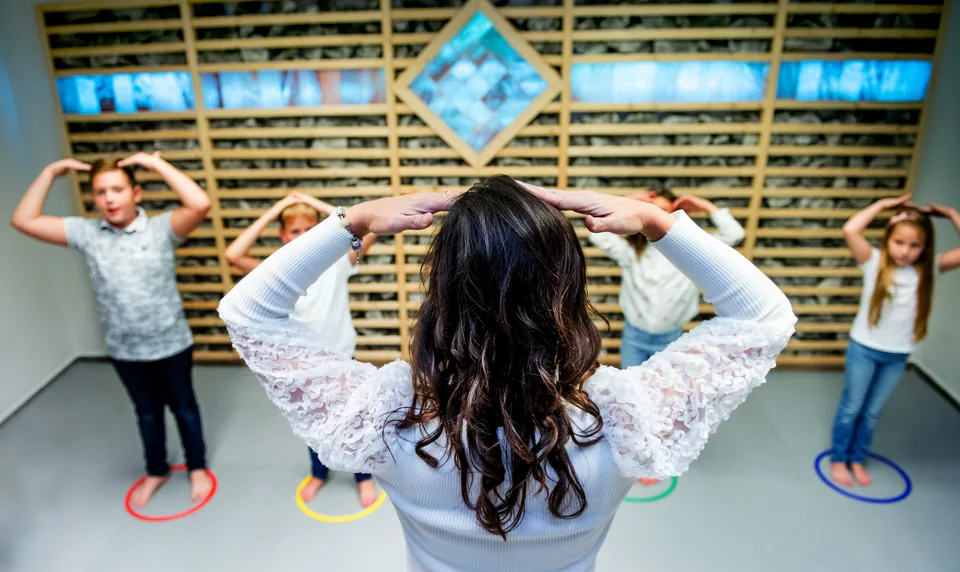 Mozgásfejlesztő gyakorlat a tornateremben – négy gyerek egyensúlyozik